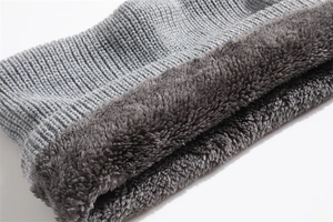 Detail of grey knitted fabric with thick plush fleece lining for winter warmth