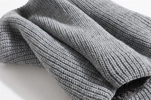 Detailed view of grey thick ribbed knit scarf with warm dark grey fleece lining