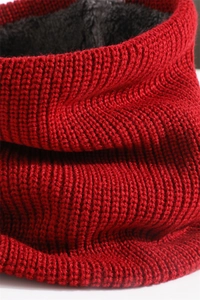 Macro shot of red knit texture and thick black fleece lining on a winter neck warmer
