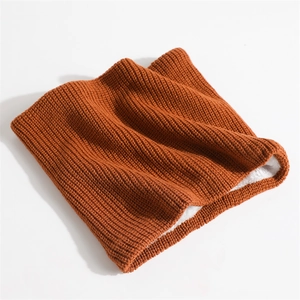 Detailed view of burnt orange ribbed knit neck warmer with thick white fleece lining