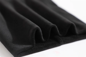 Macro shot of thick black velvet fabric showing soft texture and premium double-layer fleece