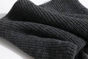 Detail of dark grey ribbed knit texture showing thick warm elastic yarn fibers