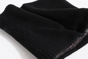 Detailed macro view of black ribbed knit fabric with thick brown fleece lining material
