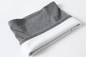 Close-up of gray knitted neck warmer showing thick white fleece lining and soft texture