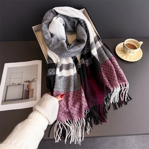 Close-up of multi-color plaid cashmere-like scarf with dense tassels and soft texture