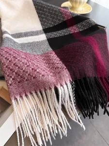 Close-up of checkered cashmere-like scarf with thick knit texture and fringe edge