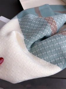 Close-up of woven cashmere plaid scarf texture in teal cream and brown tones