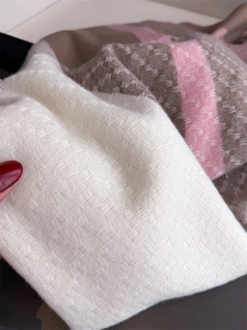 Close-up of thick twill woven scarf showing beige, brown, and pink cashmere texture