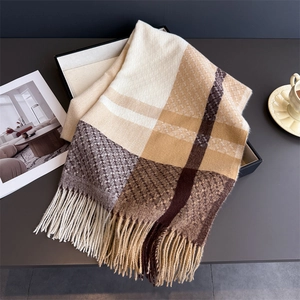 Close-up of brown plaid scarf texture with long tassels in a minimalist gift box