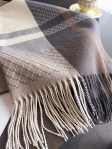 Macro view of plaid cashmere feel scarf with fringe tassels and soft knitted texture