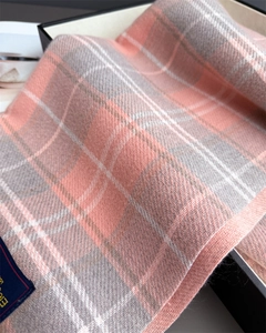 Nahaufnahme des rosa-grauen Karoschals mit weicher Kaschmir-Textur und Markenetikett