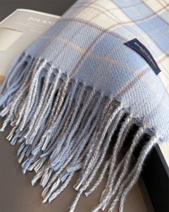 Nahaufnahme von hellblauem und beige kariertem Schal mit weicher Textur und Fransen