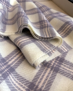 Vue détaillée de l'écharpe à carreaux lavande montrant le tissage doux à chevrons et franges