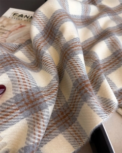 Gros plan détaillé de la texture brossée douce et du motif à carreaux classique de l'écharpe