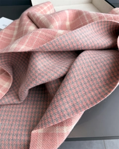 Detail of soft cashmere-feel pink plaid scarf with double-sided knit texture