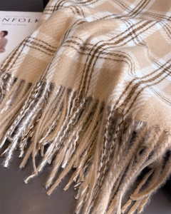 Gros plan sur la texture du foulard en cachemire à carreaux et les détails des franges