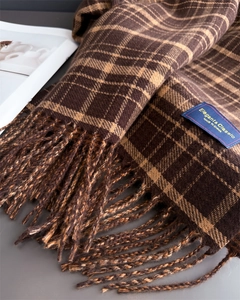 Close-up of vintage brown plaid scarf with tassels and elegant fabric texture detail