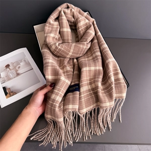 Close-up of soft plaid cashmere-feel scarf featuring elegant long tassels and woven label