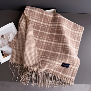 Detail of warm coffee cashmere scarf featuring classic plaid patterns and soft tassels