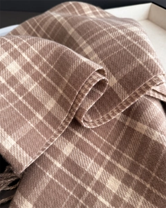 Close-up of brown and beige plaid cashmere scarf showing soft texture and fringe details