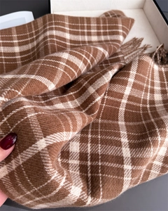 Close-up of brown plaid cashmere-like scarf showing soft knit texture and fringe details
