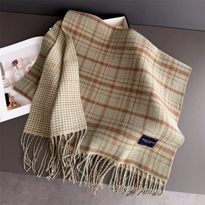 Detail of plaid fringe scarf showing double-sided check pattern and tassel texture
