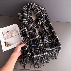 Detail of soft black and white plaid scarf with fringe and Elegant Classic label