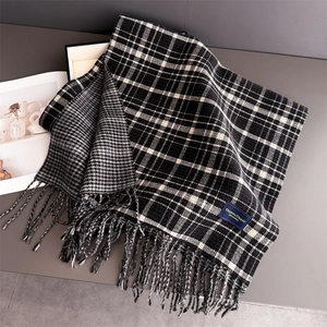 Close-up of double-sided winter scarf featuring houndstooth pattern and woven fringes