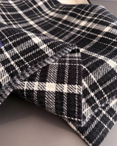 Macro shot of soft plaid cashmere texture and detailed woven tassels on the scarf