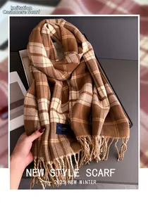 Detail view of brown plaid cashmere-like scarf with tassels in a gift box