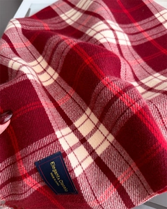 Detailed close-up of red and beige checkered scarf fabric with fine tassel weave