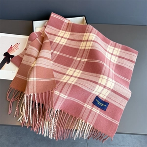 Detailed texture of pink plaid faux cashmere scarf with elegant classic woven label