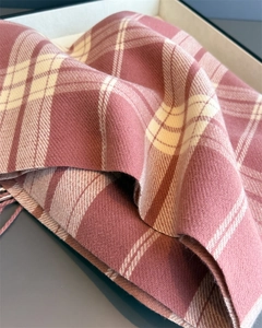 Detailed macro view of pink and white checkered cashmere texture with fringe edges