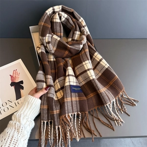 Classic plaid warm scarf in brown and beige with fringe details on a textured background