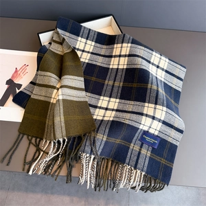 Close-up of blue and green tartan cashmere scarf with elegant tassels and woven label