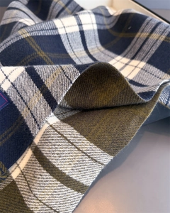 Detail of vintage plaid scarf texture with blue, white, and green wool weave patterns