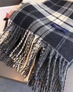 Close-up of vintage plaid cashmere scarf texture with tassels and elegant label detail