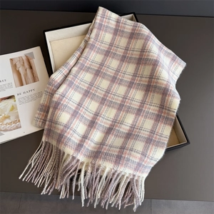 Detail of plaid scarf with tassels in a gift box with a decorative magazine
