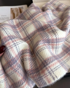 Close-up of soft plaid scarf showing pink and grey cashmere-like texture and weave