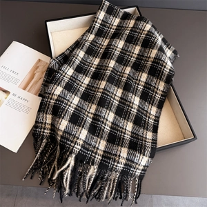 Detail of checkered plaid scarf with long tassels and thick cashmere-like texture