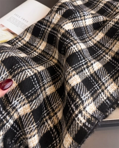 Detailed close-up of soft plaid cashmere-feel fabric with refined fringe textures