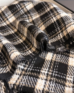 Macro detail of the soft woven cashmere-like texture and classic plaid pattern on scarf