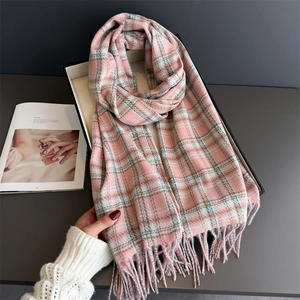 Close-up of elegant plaid tassel scarf in soft pink and grey faux cashmere texture