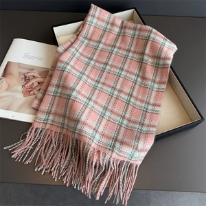 Macro shot of plaid tassel scarf texture with soft pink and blue checkered patterns