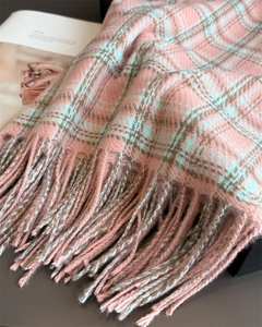 Detail of pink and blue plaid scarf with soft tassels on a fashion magazine