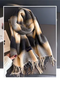 Detailed view of plaid cashmere-like scarf texture with fringe tassels and woven label