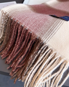 Detail of pink and beige plaid scarf showing soft cashmere texture and fringe tassel edges