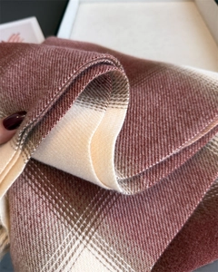 Close-up of thick plaid shawl with brick red and beige twill woven texture details