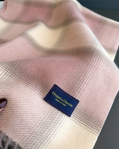 Detailed view of pink plaid scarf texture with Elegant and Classic woven label and fringes