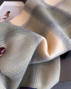 Detail shot of soft cashmere-like plaid scarf featuring twill weave and fringe texture